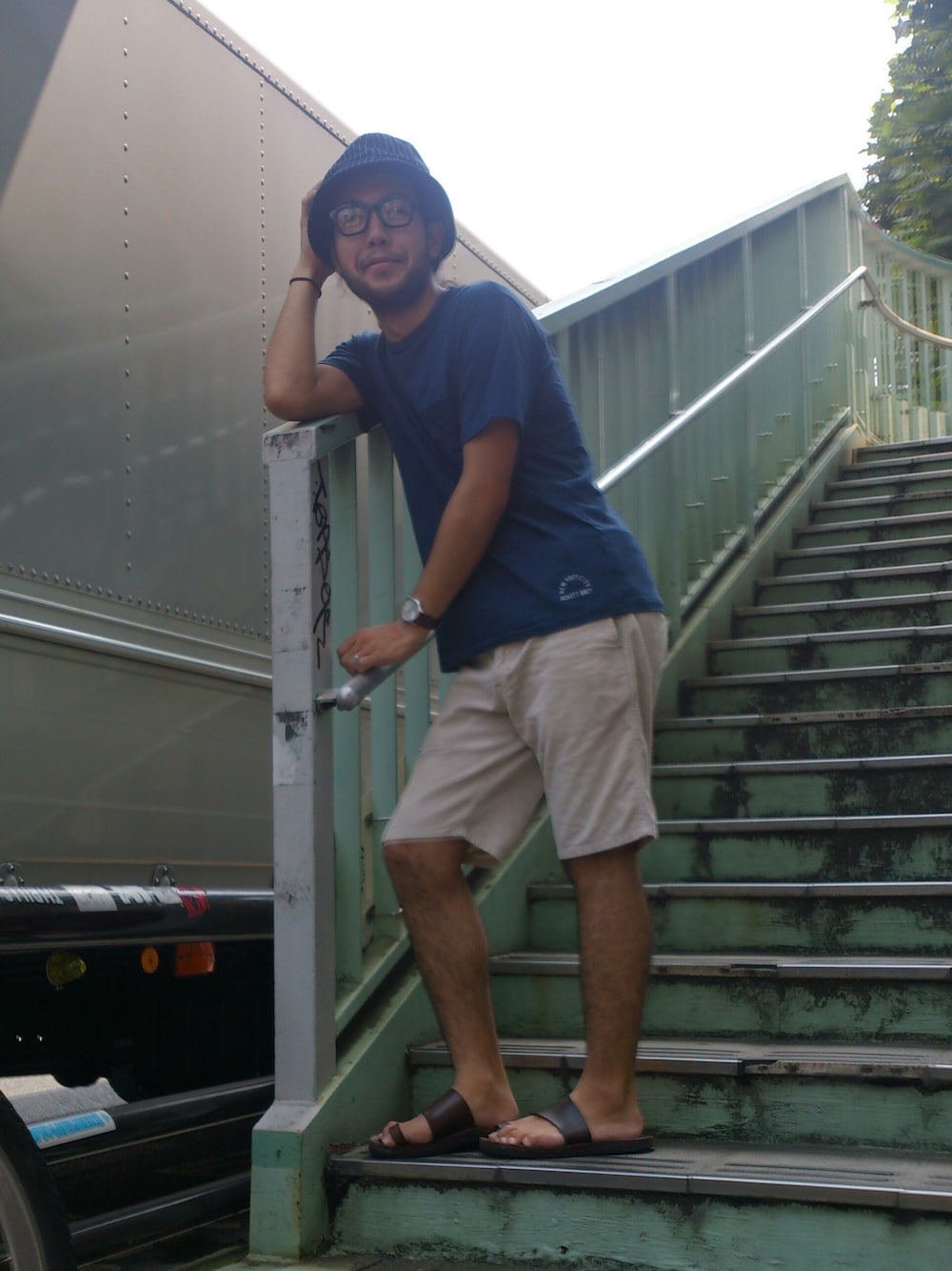 ベージュ系のスラックス、ブルー系のTシャツ/カットソー、ブルー系のファッション雑貨を着用したメンズの夏コーディネートの1枚目の写真