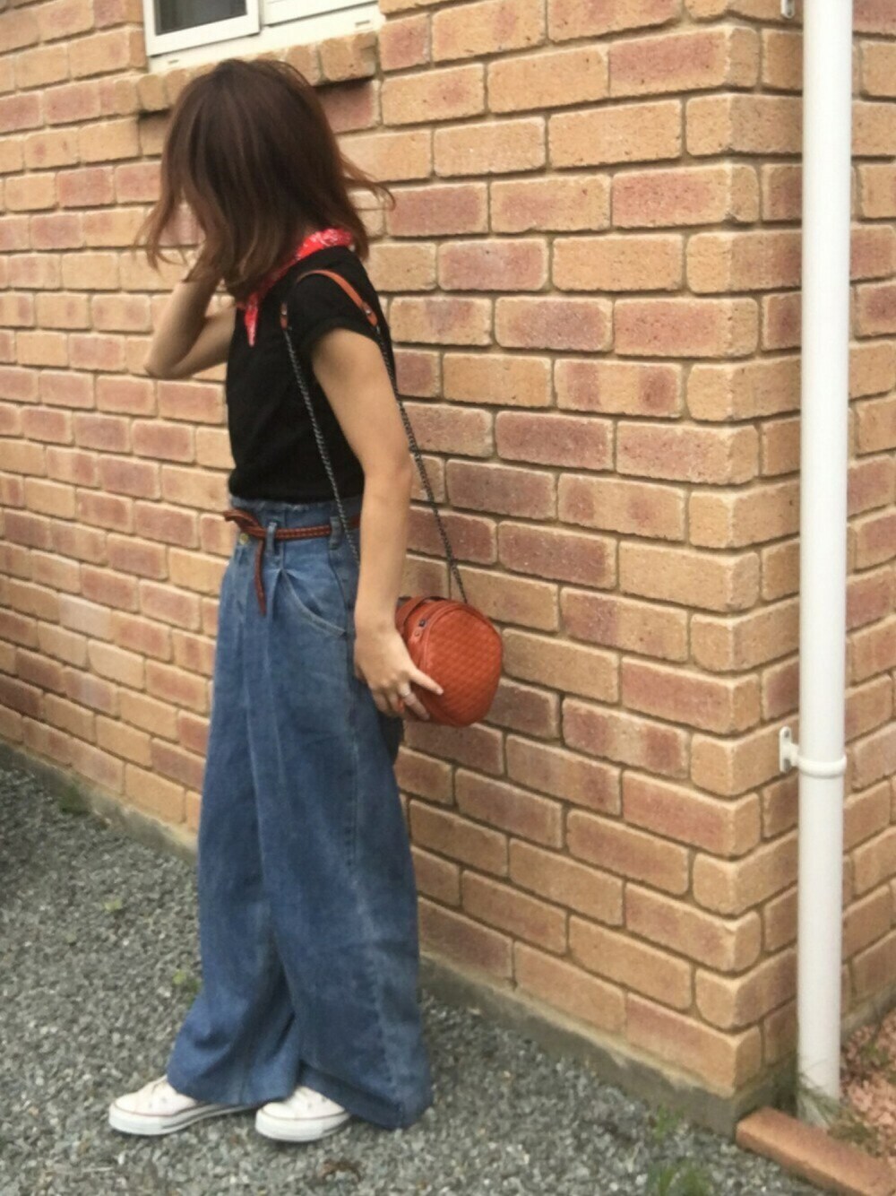 ブルー系のデニムパンツ、オレンジ系のショルダーバッグ、ホワイト系のスニーカーを着用したレディースの夏コーディネートの1枚目の写真