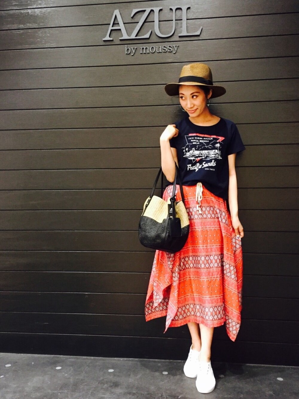 ホワイト系のスリッポン、レッド系のスカート、ベージュ系のショルダーバッグを着用したレディースの春コーディネートの1枚目の写真