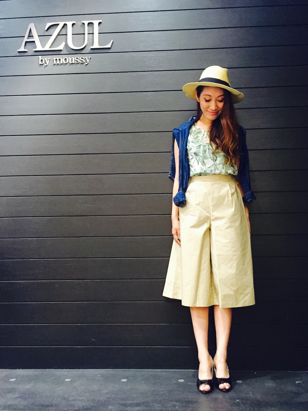 グリーン系のトップス、ブルー系のシャツ/ブラウス、ベージュ系のパンツを着用したレディースの夏コーディネートの1枚目の写真