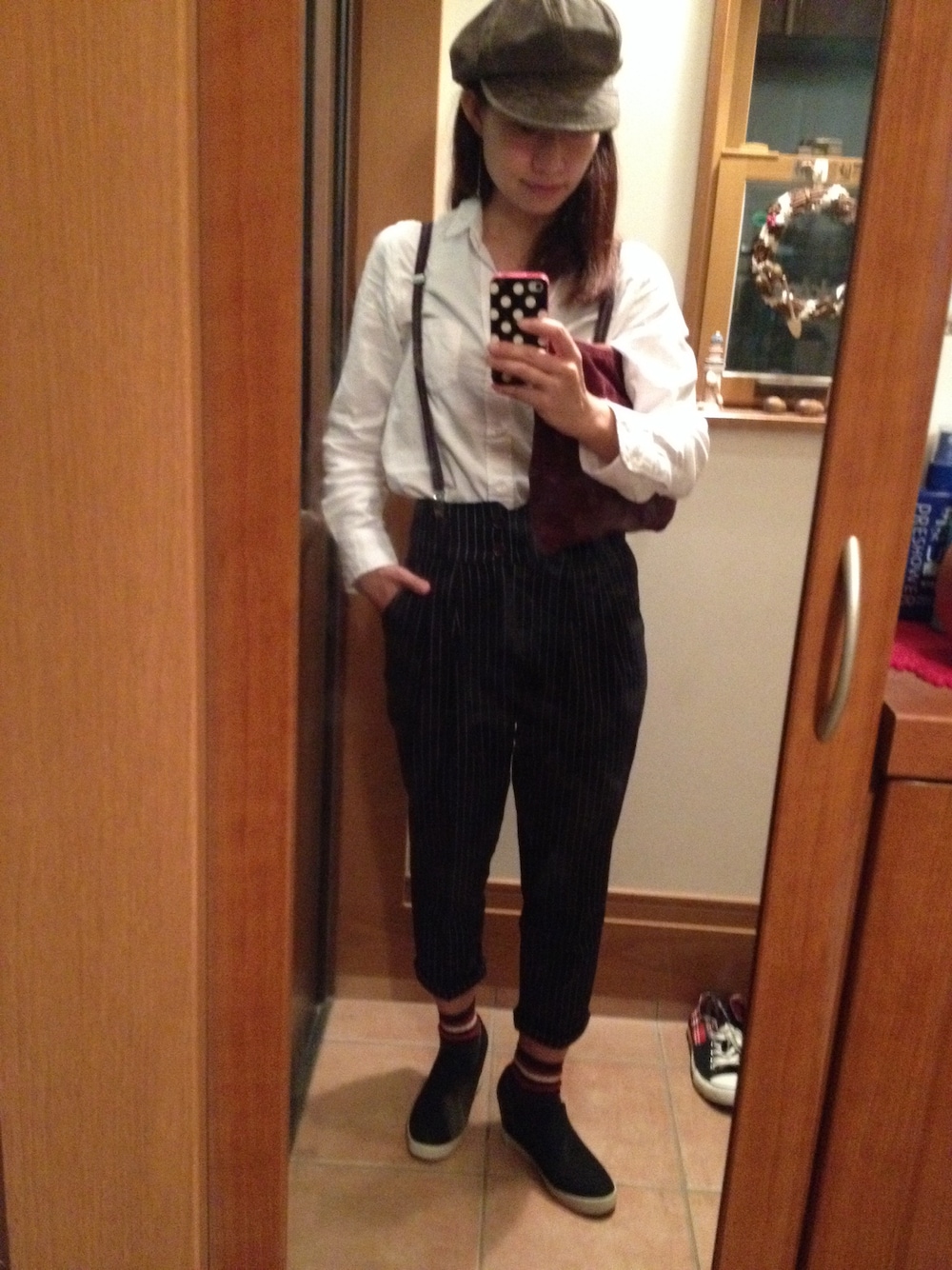 ブラック系のその他シューズ、レッド系のクラッチバッグ、ブラウン系のキャスケットを着用したレディースの秋コーディネートの1枚目の写真