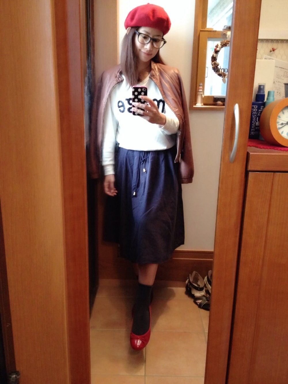 ブラウン系のブルゾン、レッド系のハンチング/ベレー帽を着用したレディースの秋コーディネートの1枚目の写真