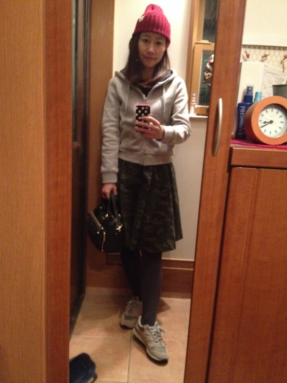 グレー系のスニーカー、グリーン系のスカート、ブラック系のボストンバッグを着用したレディースの秋コーディネートの1枚目の写真