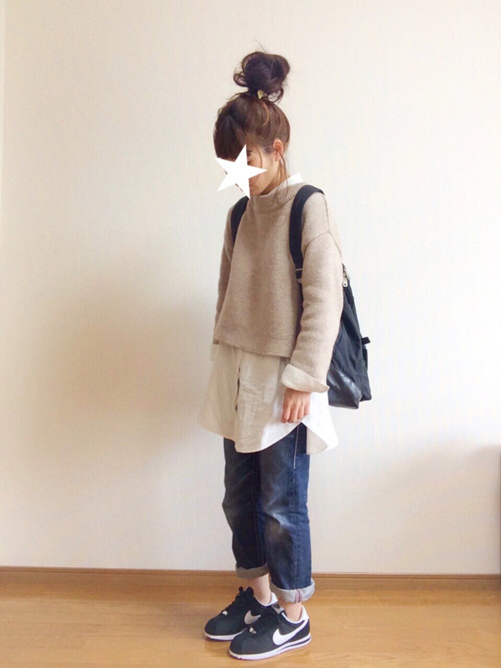 ベージュ系のニット/セーター、ブラック系のスニーカー、ブラック系のバックパック/リュックを着用したレディースの冬コーディネートの1枚目の写真