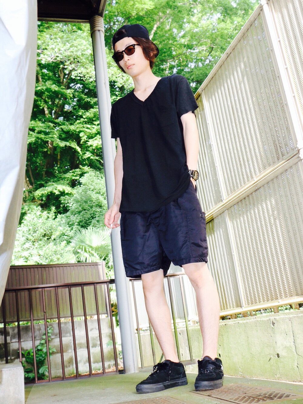 ブラック系のスニーカー、ブルー系のカーゴパンツ、ブラック系のその他トップスを着用したメンズの夏コーディネートの1枚目の写真