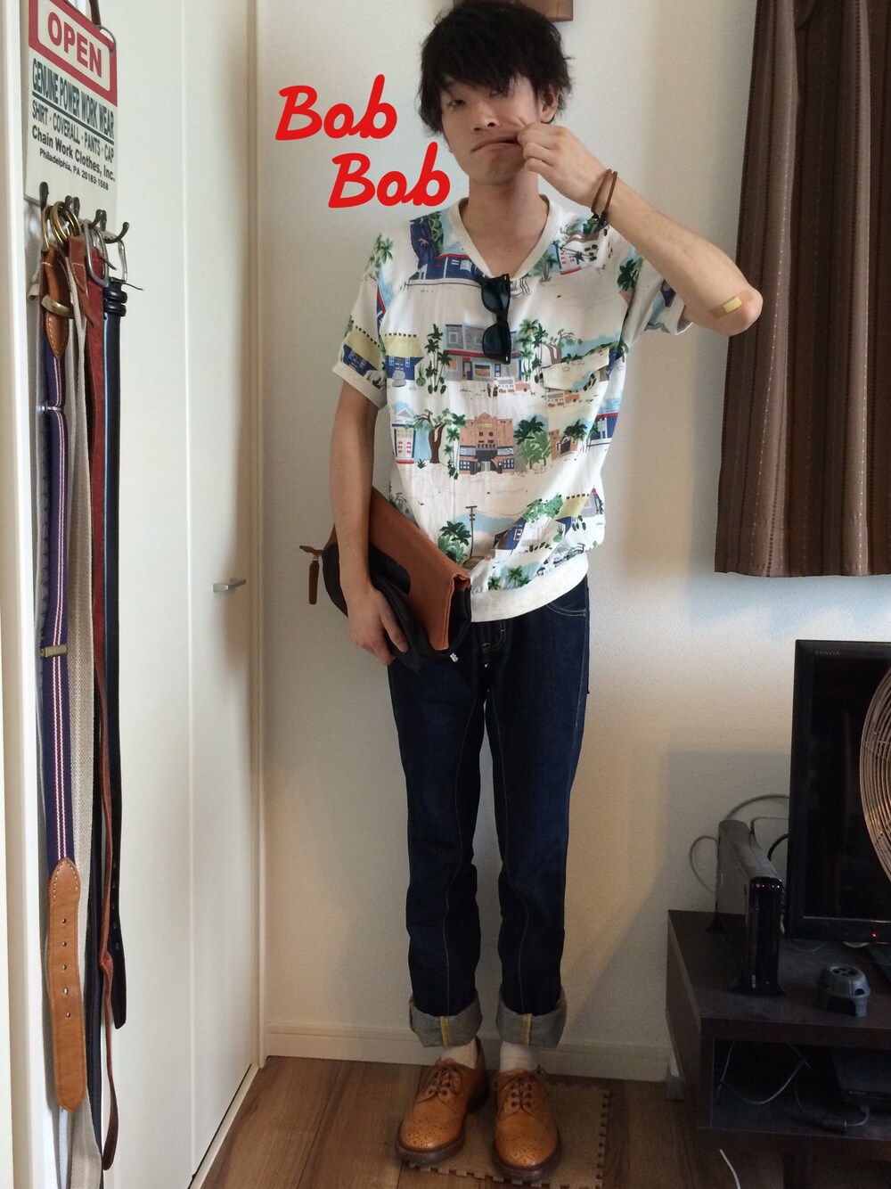 ホワイト系のTシャツ/カットソー、ブラウン系のクラッチバッグ、ブルー系のデニムパンツを着用したメンズの夏コーディネートの1枚目の写真