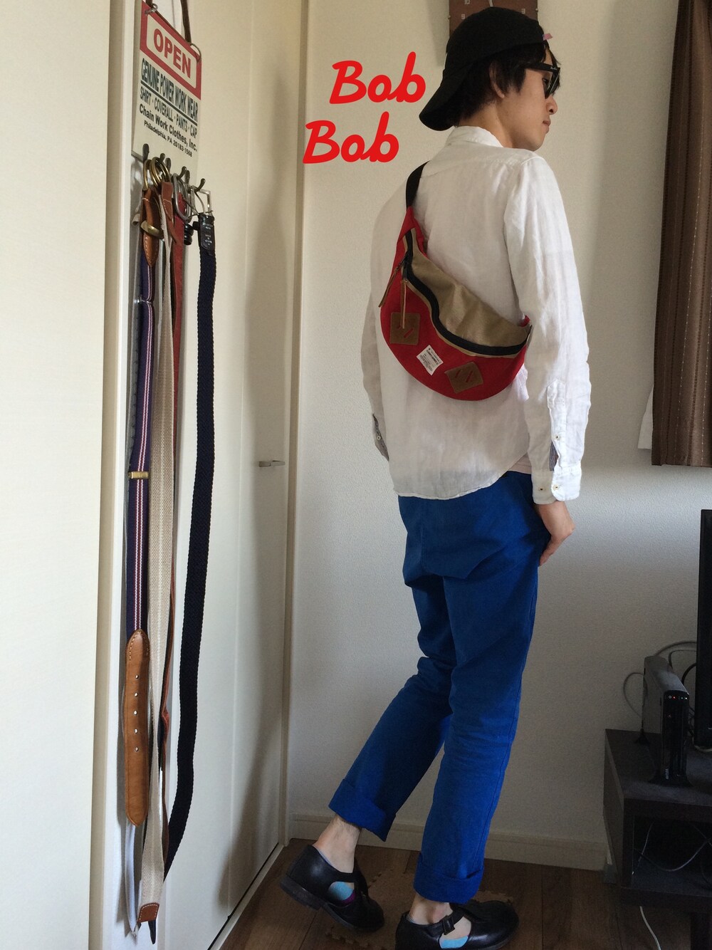 ブルー系のその他パンツ、レッド系のボディバッグ/ウエストポーチ、ブラック系のドレスシューズを着用したメンズの秋コーディネートの1枚目の写真