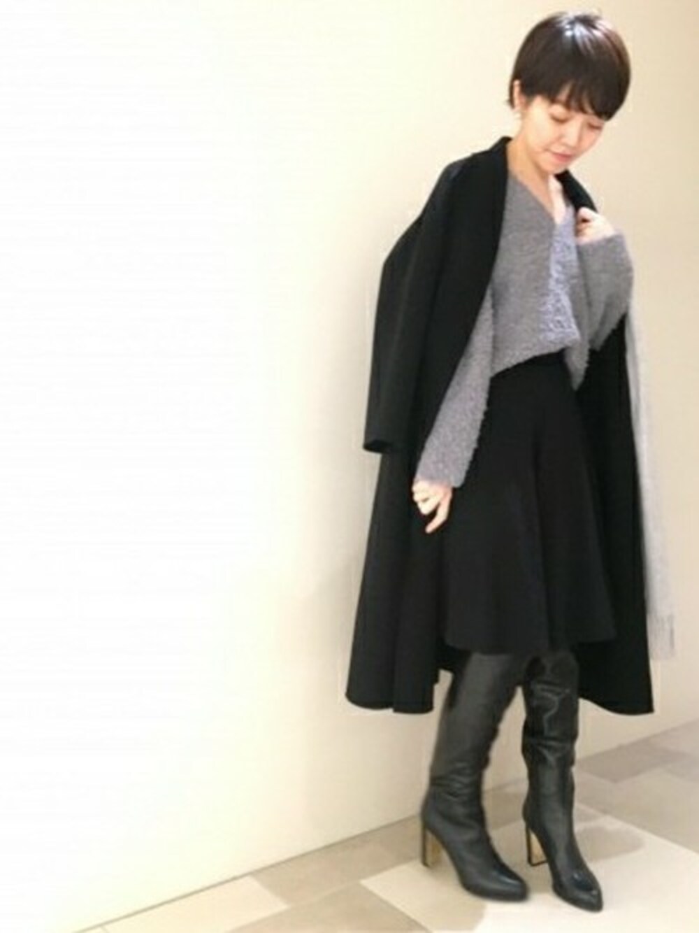 ブラック系のその他アウター、グレー系のニット/セーター、ブラック系のその他パンツを着用したレディースの冬コーディネートの1枚目の写真