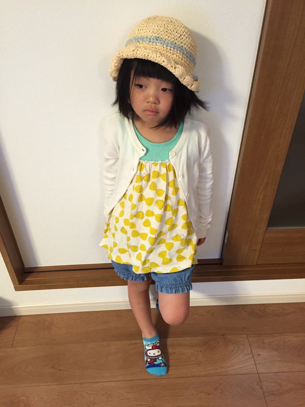 ホワイト系のカーディガン/ボレロ、イエロー系のTシャツ/カットソー、ブルー系のデニムパンツを着用したキッズの春コーディネートの1枚目の写真