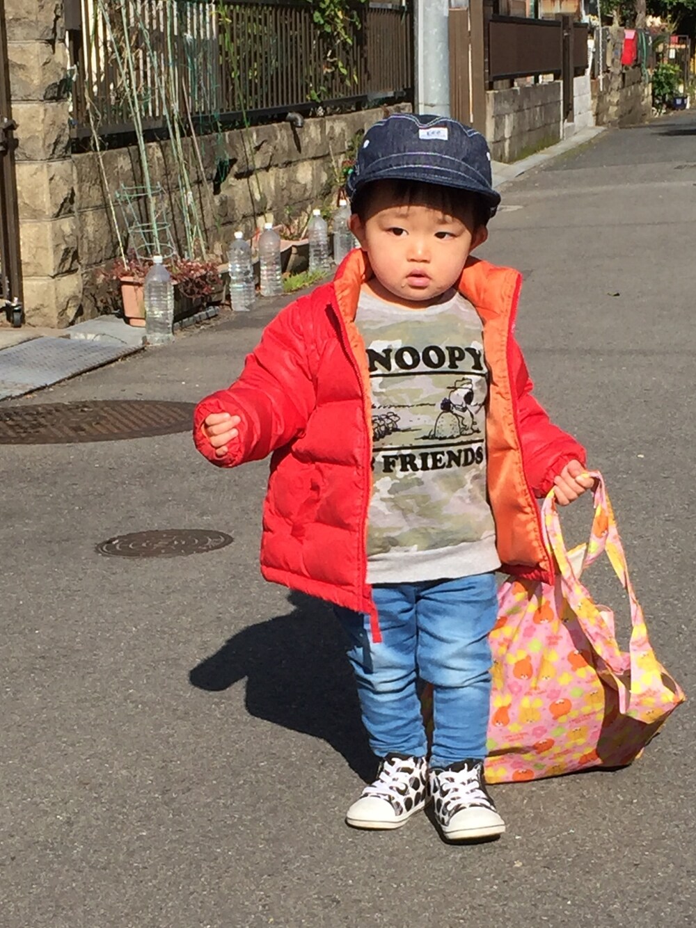 レッド系のダウンジャケット/コート、ブルー系のデニムパンツ、ホワイト系のスニーカーを着用したキッズの冬コーディネートの1枚目の写真