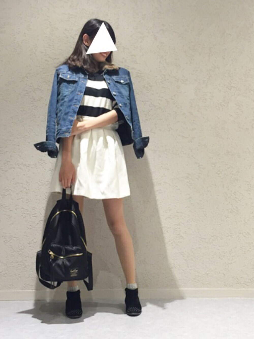 ホワイト系のニット/セーター、ホワイト系のスカート、ブラック系のバックパック/リュックを着用したレディースの秋コーディネートの1枚目の写真