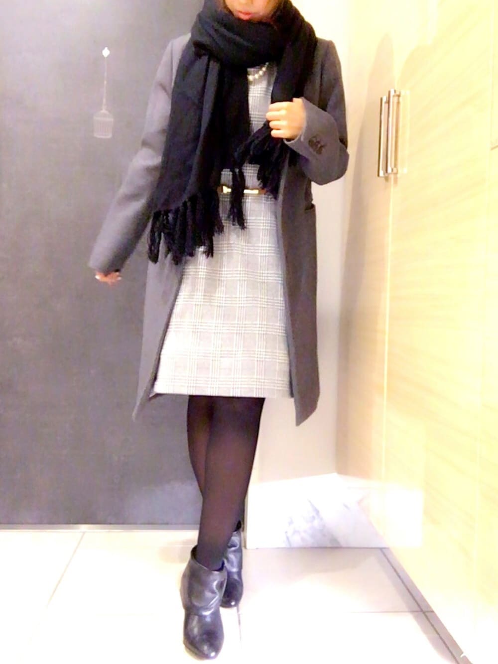 グレー系のチェスターコート、グレー系のワンピース、ブラック系のブーツを着用したレディースの秋コーディネートの1枚目の写真