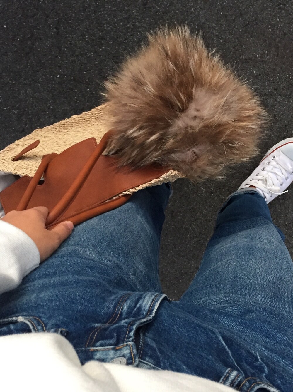 ブラウン系のかごバッグ、ブルー系のデニムパンツを着用したレディースの秋コーディネートの1枚目の写真