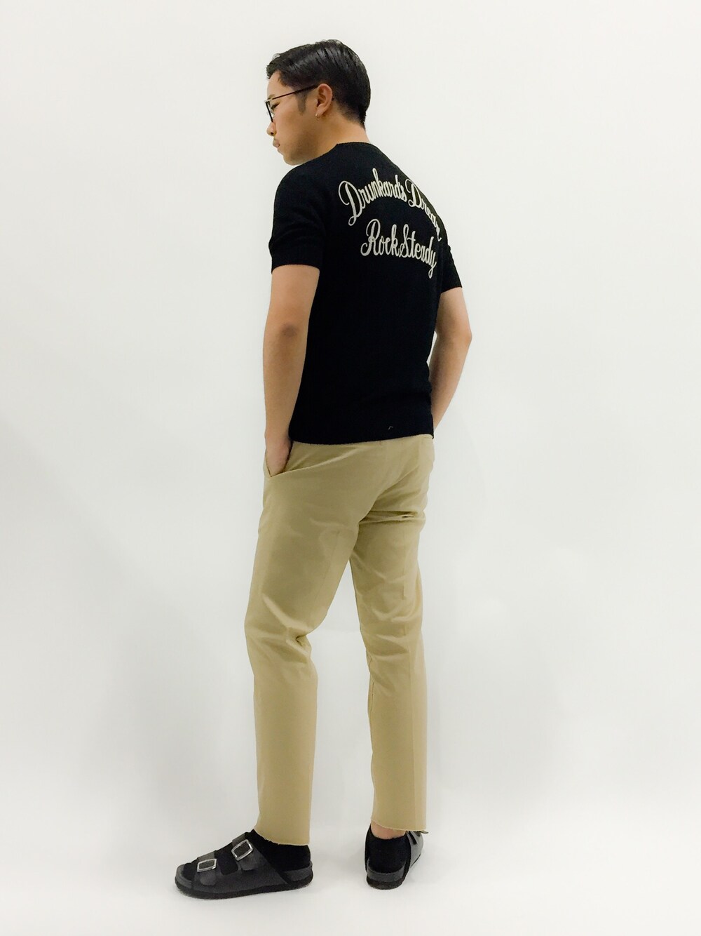 「黒ニット、チノパン、サンダル、サンダルに靴下、ルード、七三分けヘアー、メガネ男子」｜「AmbのAmb　PISSARRO KIPS（サンダル、ブラック系）」を使った、K-1RO(ケーイチロー)さん（メンズ・171cm）の春コーディネートの1枚目の写真