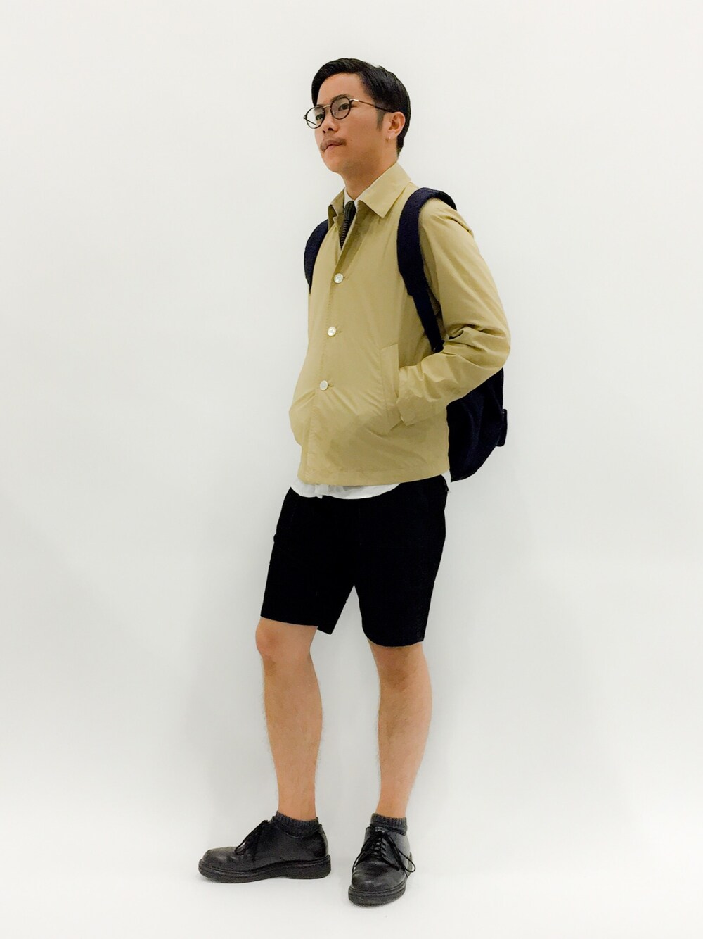 「カバーオール、革靴、七三分けヘアー、メガネ男子、タイドアップ、シャツ×タイ、ショーツスタイル、ベージュコーデ、バックパック」｜「PROJECT SR'ESの【RELI】コーデュロイブッシュショーツ（その他パンツ、ブラック系）」を使った、K-1RO(ケーイチロー)さん（メンズ・171cm）の春コーディネートの1枚目の写真