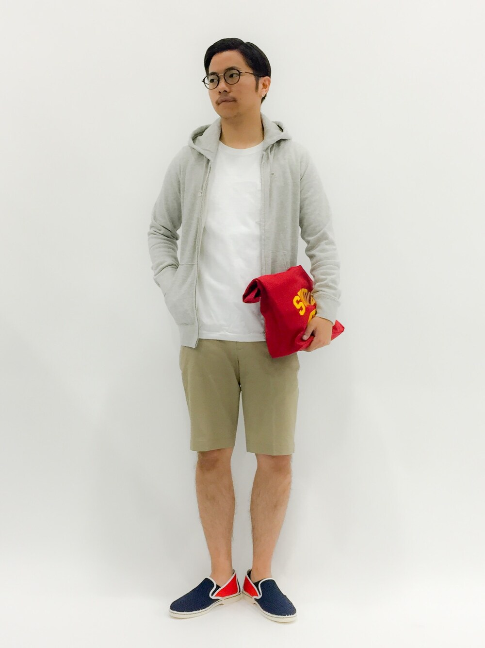 「クラッチバッグ、スリッポン、グレーのパーカー、リラックススタイル、メガネ男子、ポケT、白Tシャツ、ショーツスタイル、七三分けヘアー」｜「GLOBAL WORKのストレッチチノショーツ/563307（チノパンツ、ベージュ系）」を使った、K-1RO(ケーイチロー)さん（メンズ・171cm）の春コーディネートの1枚目の写真