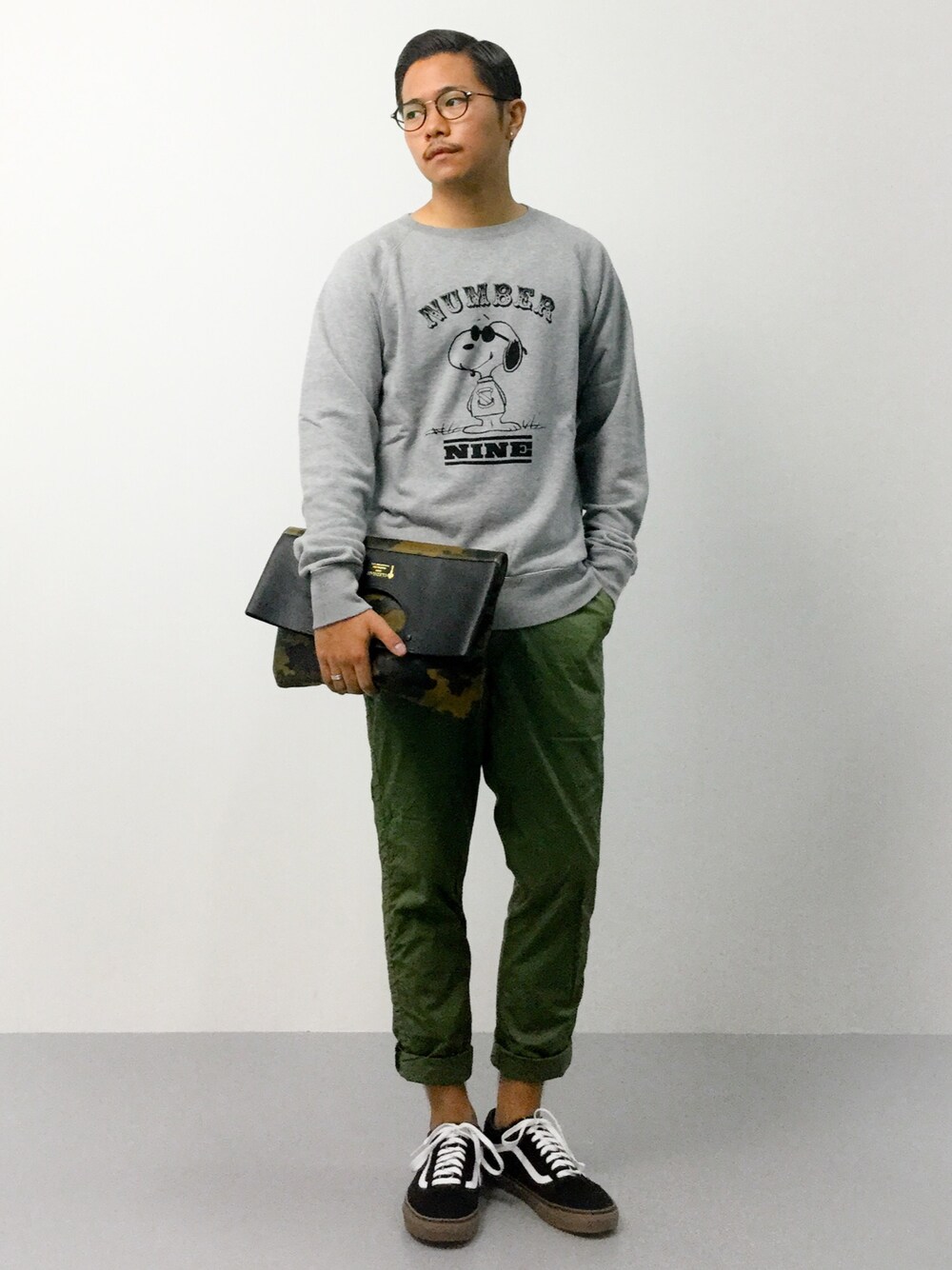 「テーパードパンツ、スウェット、VANS、カモフラ、クラッチバッグ、スヌーピー、丸メガネ、スウェットトップス、VANSのスニーカー、NUMBER (N)INE」｜「NUMBER (N)INEのNUMBER (N)INE(ナンバーナイン)/ x PEANUTS EMBLEM SWEAT（スウェット、グレー系）」を使った、K-1RO(ケーイチロー)さん（メンズ・171cm）の夏コーディネートの1枚目の写真