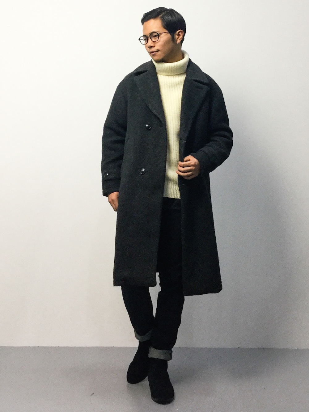 ホワイト系のニット/セーター、グレー系のチェスターコート、ブラック系のデニムパンツを着用したメンズの秋コーディネートの1枚目の写真