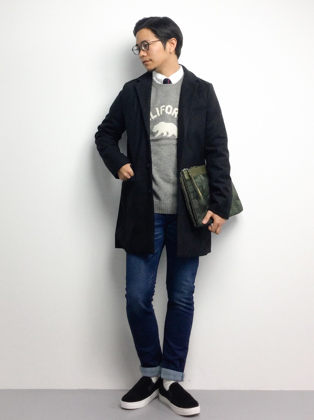 「クラッチバッグ、スリッポン、デニムパンツ、丸メガネ、白ソックス、ロゴニット、ロールアップ、冬、きれいめカジュアル、オトナカジュアル」｜「BEAMSのBEAMS / サガラ エンブレム ニット（ニット/セーター、その他）」を使った、K-1RO(ケーイチロー)さん（メンズ・171cm）の冬コーディネートの1枚目の写真