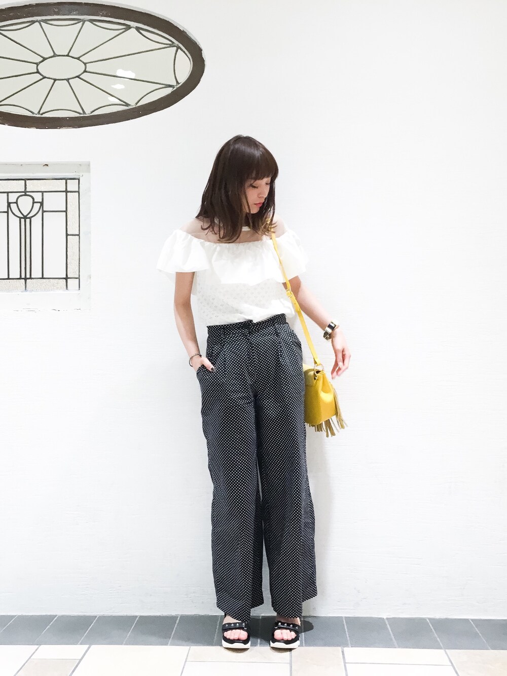 ブラック系のその他パンツ、ブラック系のサンダル、イエロー系のショルダーバッグを着用したレディースの春コーディネートの1枚目の写真