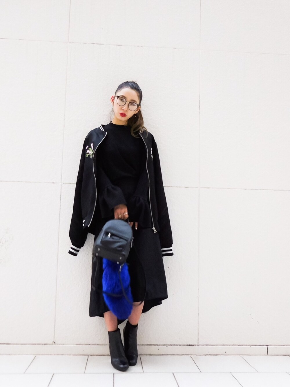 ブラック系のTシャツ/カットソー、ブラック系のバックパック/リュック、ブラック系のスタジャンを着用したレディースの秋コーディネートの1枚目の写真