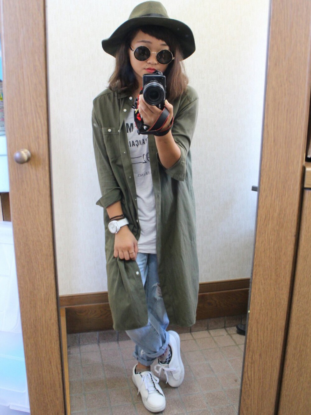 ホワイト系のトップス、グリーン系のトップス、ブルー系のパンツを着用したレディースの秋コーディネートの1枚目の写真