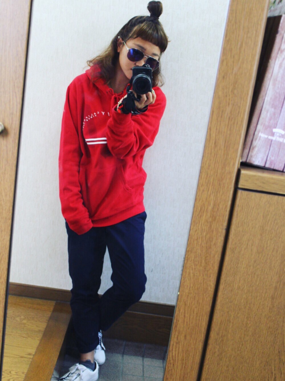 ブルー系のパンツ、ホワイト系のスニーカー、レッド系のトップスを着用したレディースの秋コーディネートの1枚目の写真