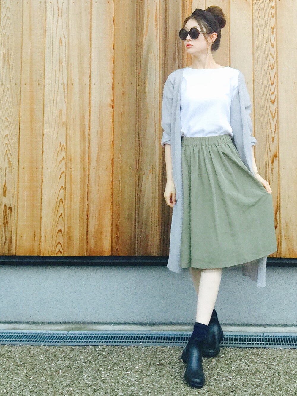 グリーン系のスカート、ホワイト系のTシャツ/カットソー、ブラック系のレインシューズを着用したレディースの夏コーディネートの1枚目の写真