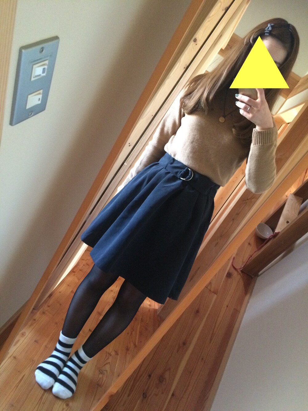 ブラック系のスカート、ブラウン系のニット/セーター、ホワイト系のソックス/靴下を着用したレディースの冬コーディネートの1枚目の写真