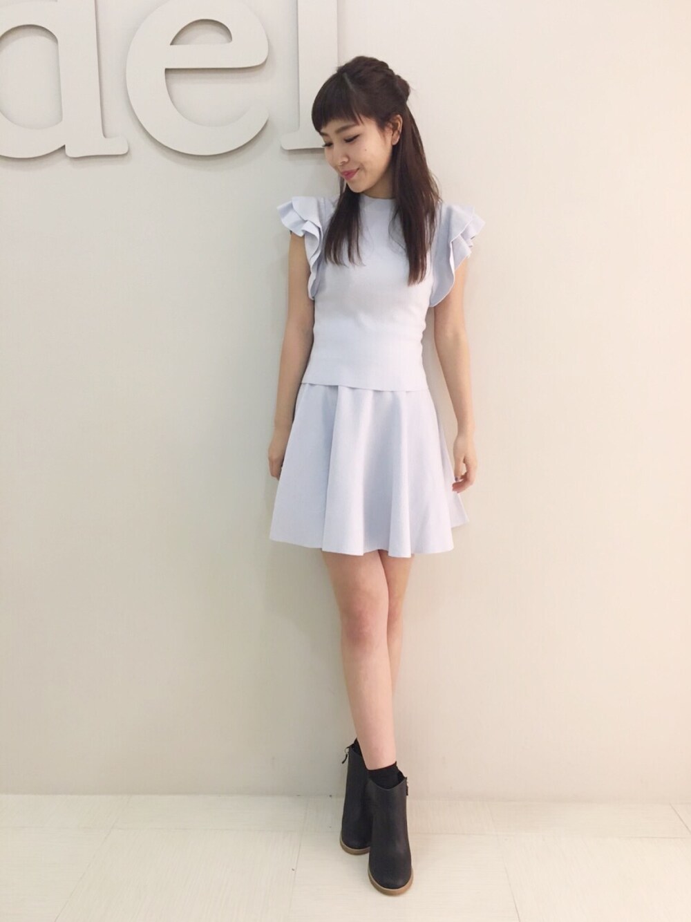 ブルー系のトップス、ブルー系のスカート、ブラック系のブーツを着用したレディースの冬コーディネートの1枚目の写真