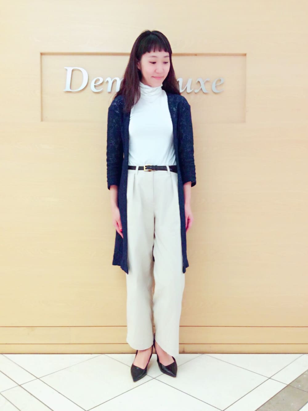 ベージュ系のチノパンツ、ブラック系のパンプス、ブラック系のベルトを着用したレディースの春コーディネートの1枚目の写真