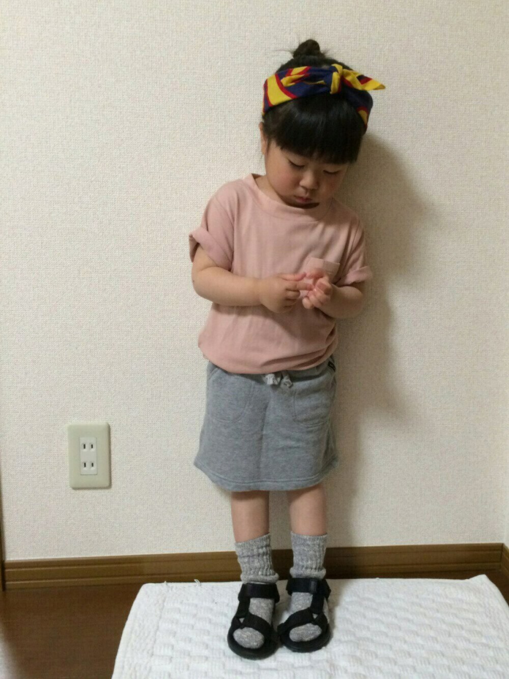 ピンク系のTシャツ/カットソー、グレー系のスカート、ブラック系のサンダルを着用したキッズの春コーディネートの1枚目の写真