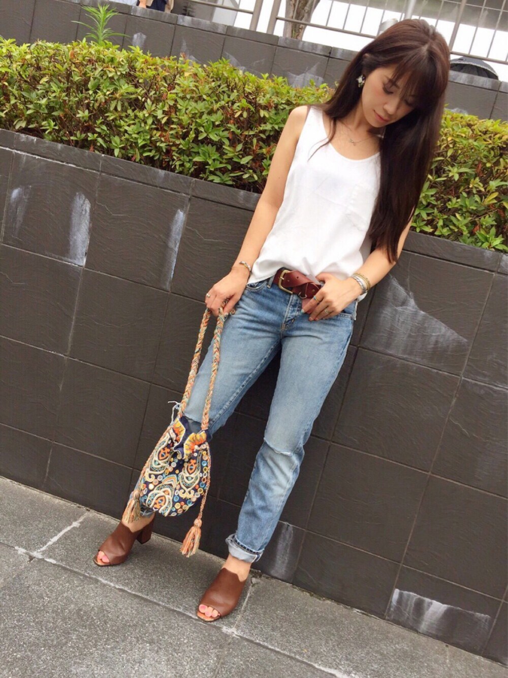 ホワイト系のタンクトップ、ブルー系のデニムパンツ、その他のショルダーバッグを着用したレディースの夏コーディネートの1枚目の写真