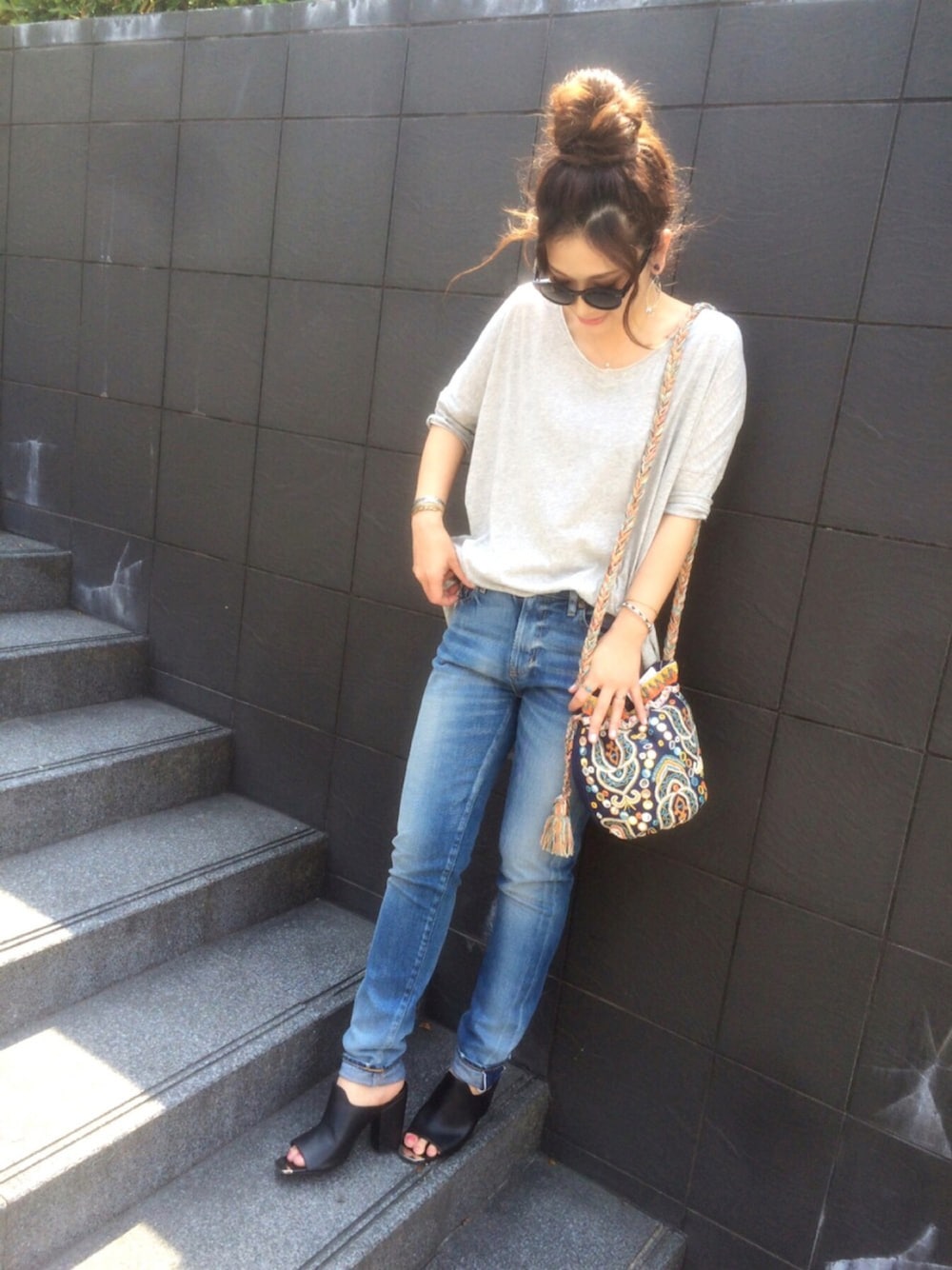 グレー系のTシャツ/カットソー、ブルー系のデニムパンツ、その他のショルダーバッグを着用したレディースの夏コーディネートの1枚目の写真