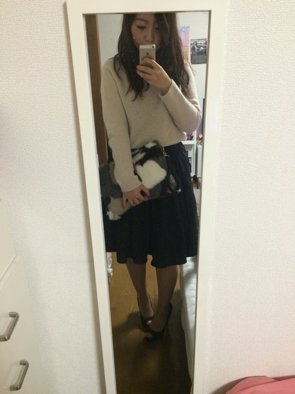 ベージュ系のニット/セーター、ブラック系のスカート、ブラック系のパンプスを着用したレディースの秋コーディネートの1枚目の写真