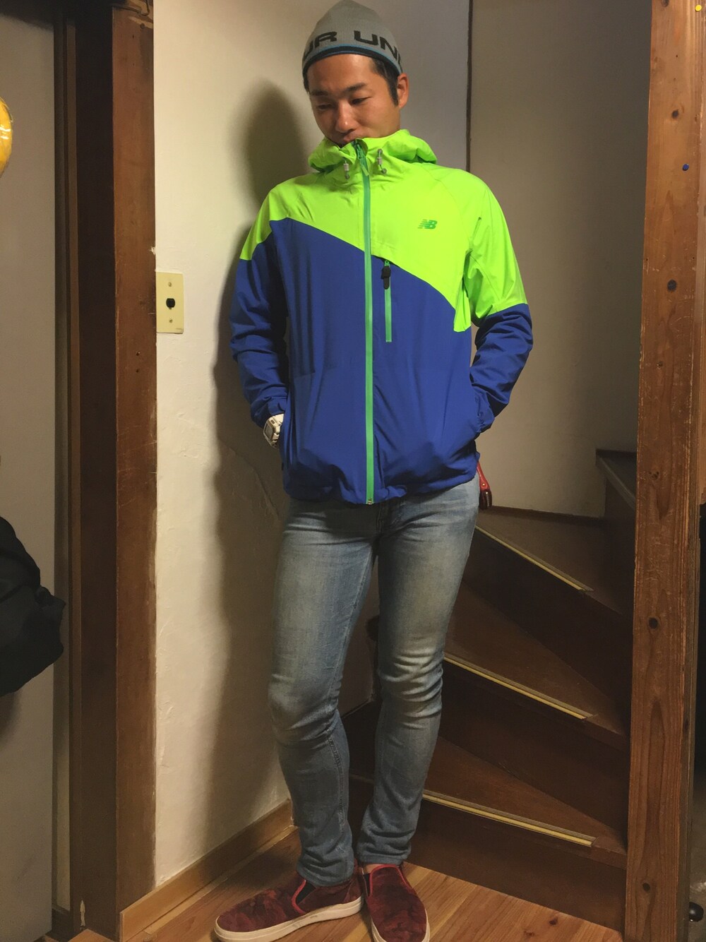 ブルー系のナイロンジャケット、ブルー系のデニムパンツ、レッド系のスニーカーを着用したメンズの秋コーディネートの1枚目の写真