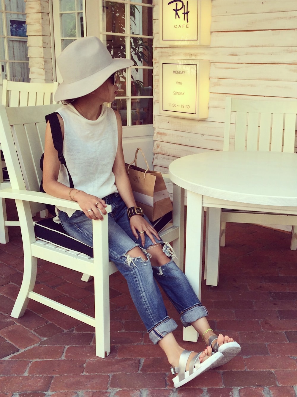 ホワイト系のニット/セーター、ブルー系のデニムパンツ、ブラック系のバックパック/リュックを着用したレディースの夏コーディネートの1枚目の写真