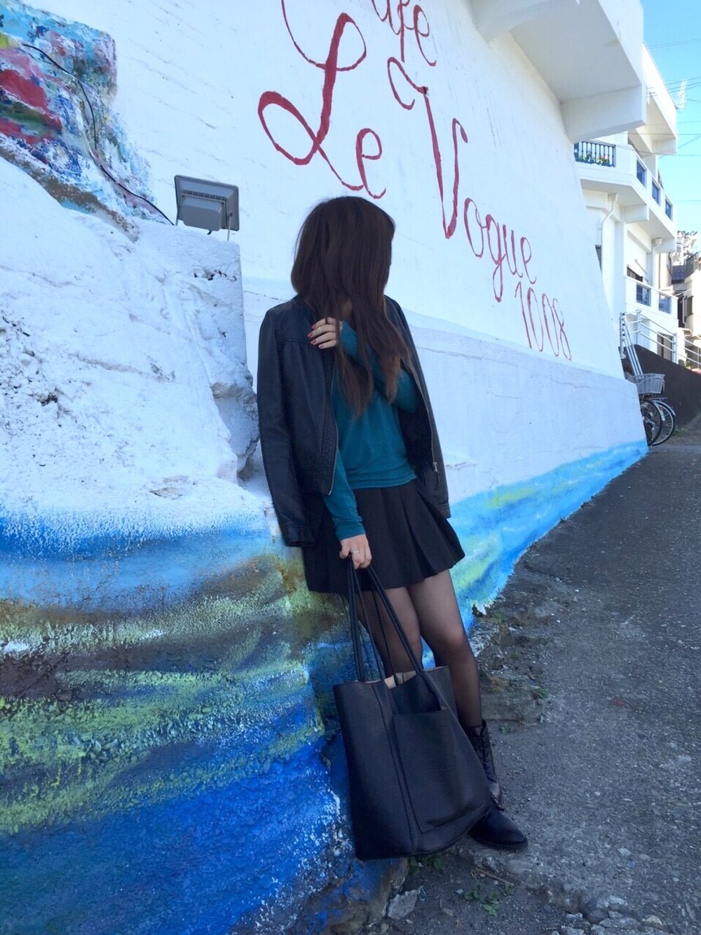 ブラック系のライダースジャケット、ブラック系のスカート、ブラック系のブーツを着用したレディースの秋コーディネートの1枚目の写真