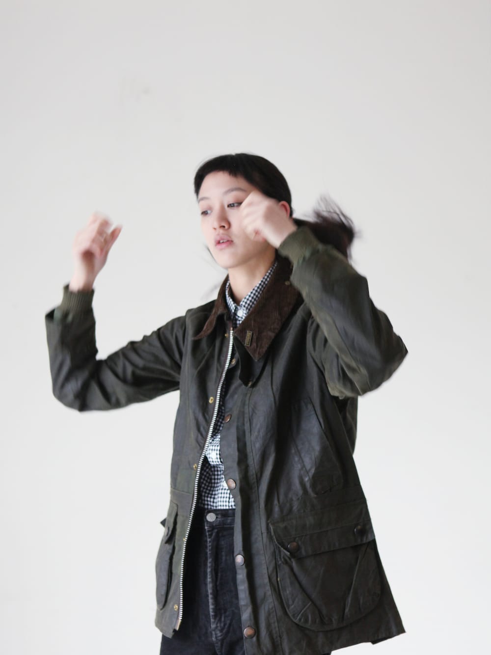 グリーン系のライダースジャケットを着用したレディースの冬コーディネートの1枚目の写真