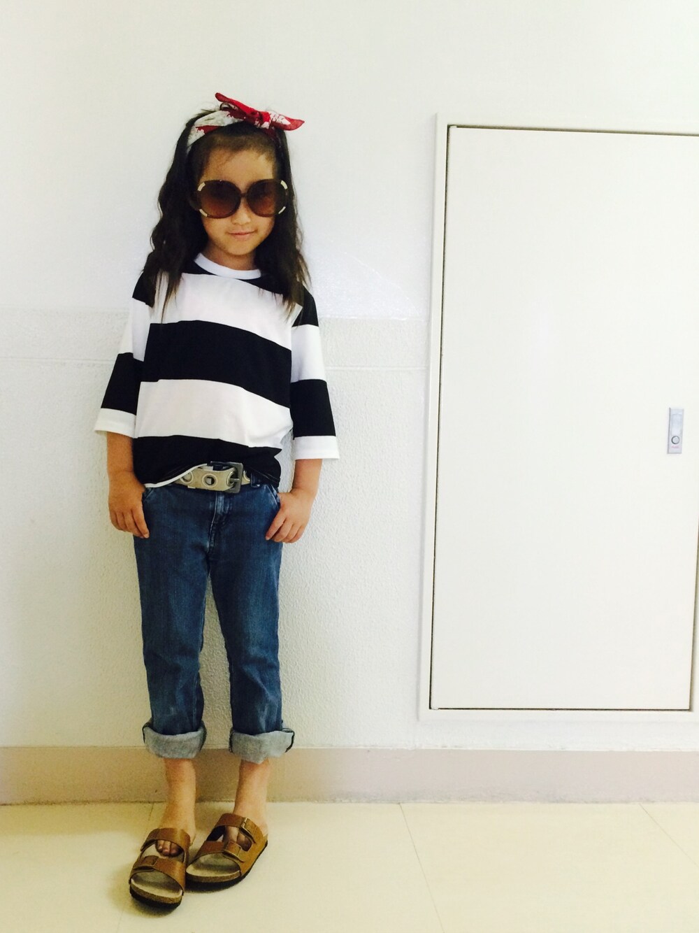 ブルー系のデニムパンツ、その他のTシャツ/カットソー、ブラウン系のサンダルを着用したキッズの春コーディネートの1枚目の写真