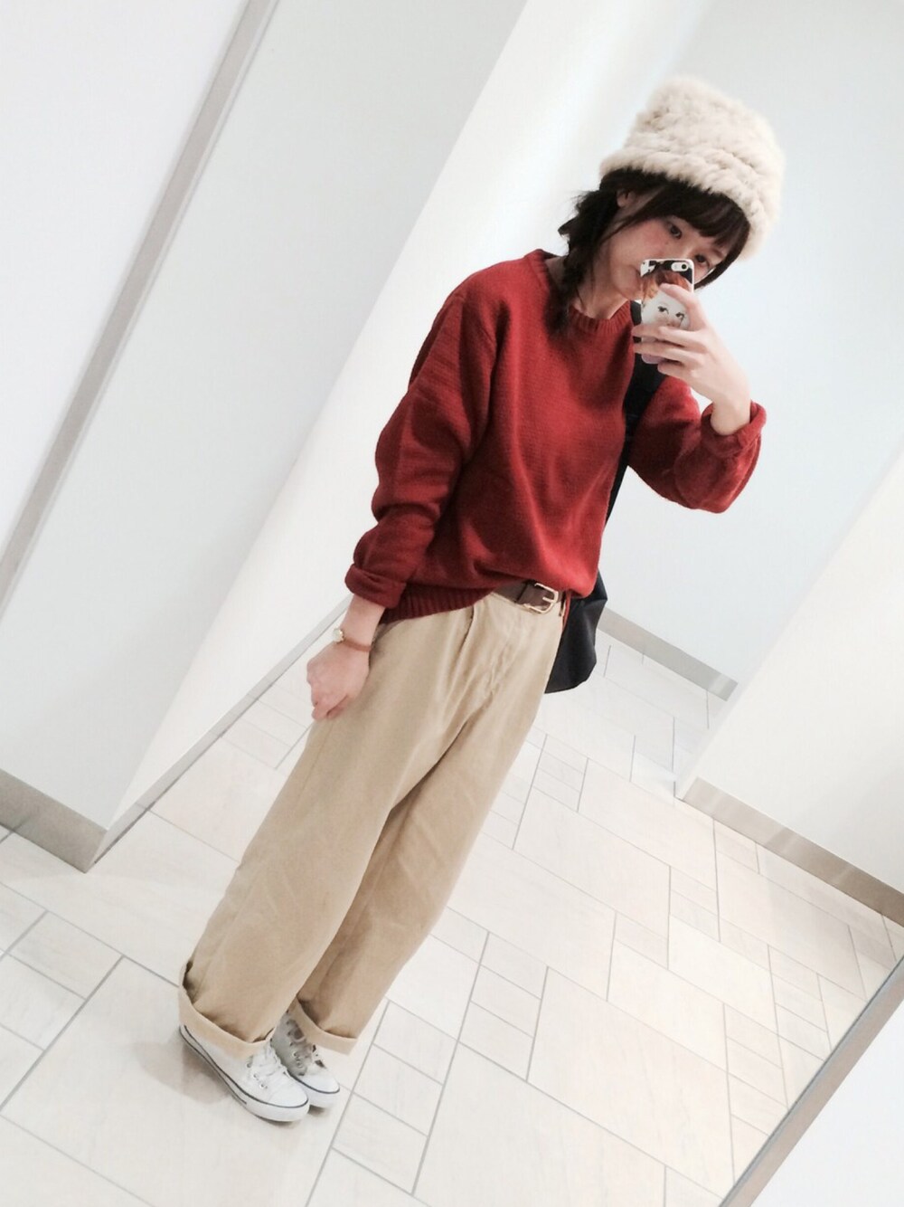 ベージュ系のパンツ、ホワイト系のシューズ、オレンジ系のニット/セーターを着用したレディースの秋コーディネートの1枚目の写真