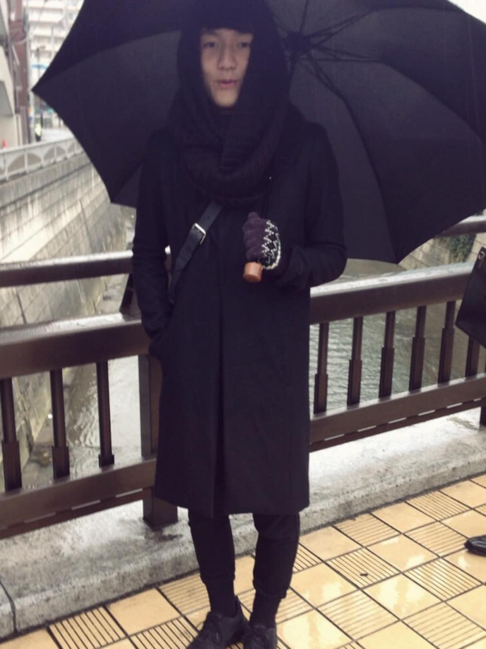 ブラック系のダウンジャケット/コート、ブラック系のショルダーバッグ、グレー系のニット/セーターを着用したメンズの冬コーディネートの1枚目の写真