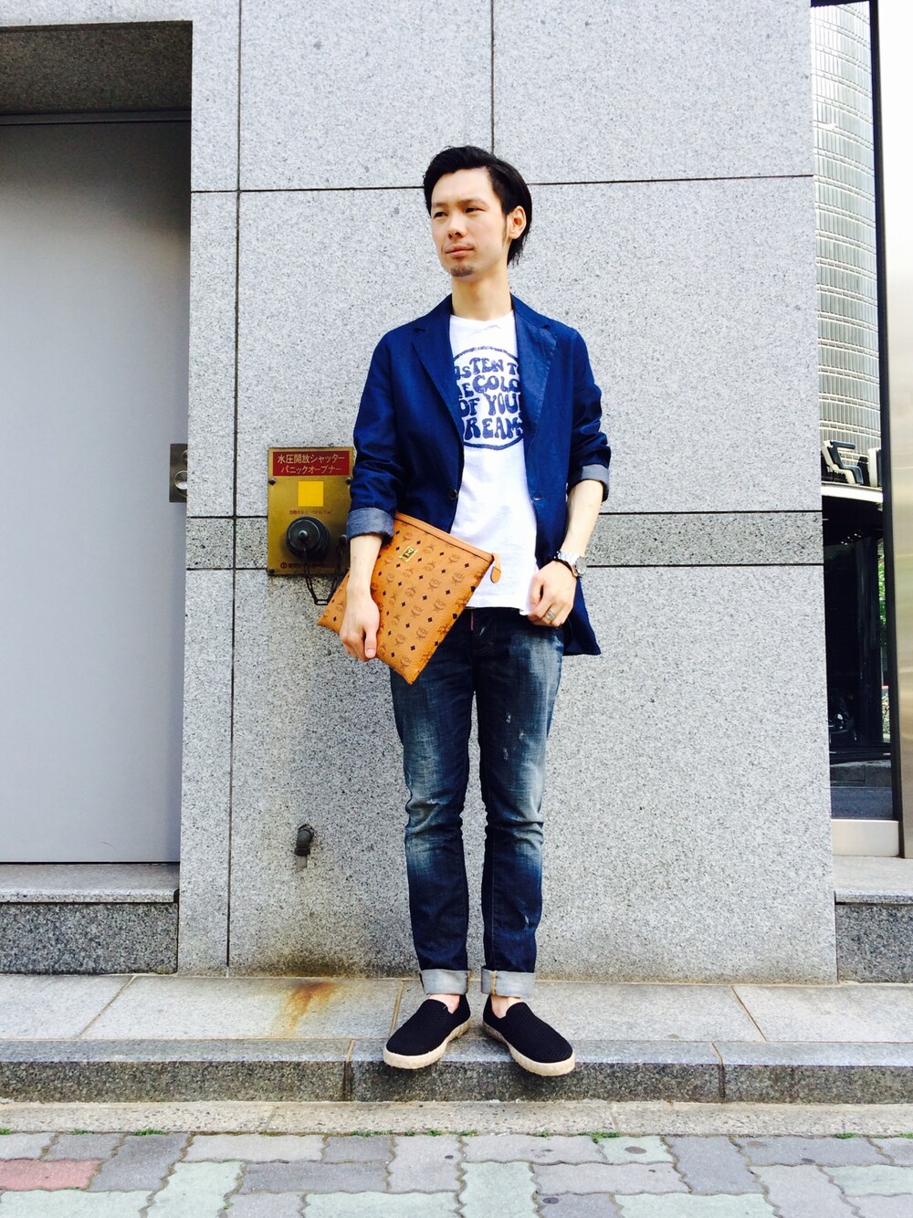 ブラウン系のクラッチバッグを着用したメンズの春コーディネートの1枚目の写真