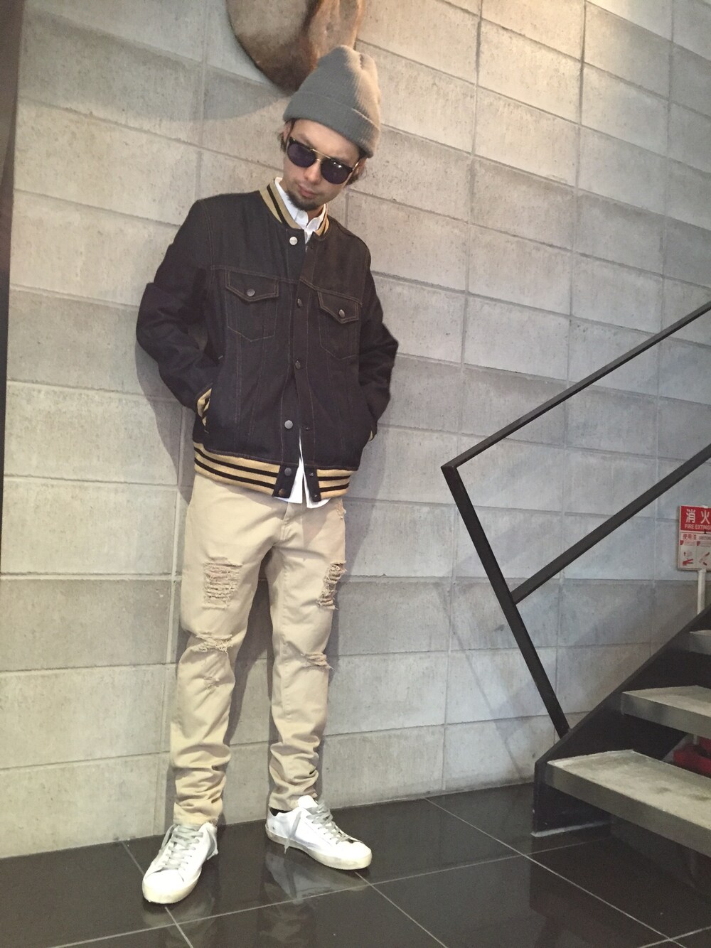 ホワイト系のスニーカー、ベージュ系のチノパンツ、ブルー系のデニムジャケットを着用したメンズの春コーディネートの1枚目の写真