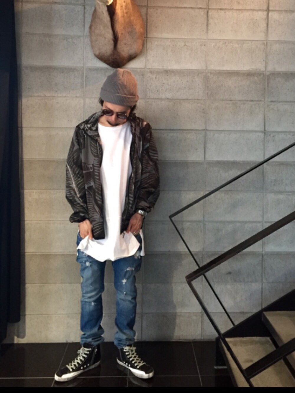 ブラック系のスニーカー、ブルー系のデニムパンツ、ホワイト系のTシャツ/カットソーを着用したメンズの夏コーディネートの1枚目の写真