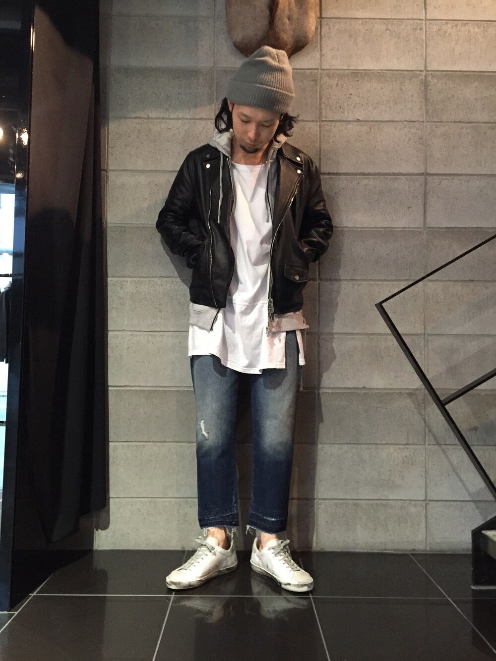 ブルー系のデニムパンツ、グレー系のTシャツ/カットソー、ブラック系のライダースジャケットを着用したメンズの秋コーディネートの1枚目の写真