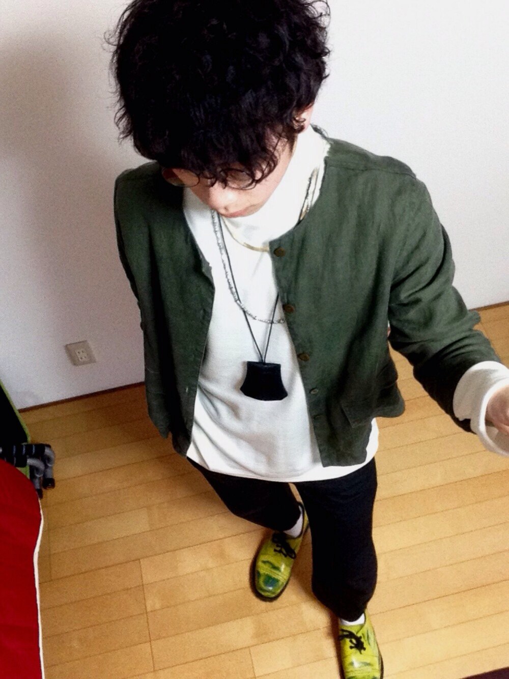 グリーン系のノーカラージャケット、ホワイト系のニット/セーター、ブラック系のその他パンツを着用したメンズの冬コーディネートの1枚目の写真