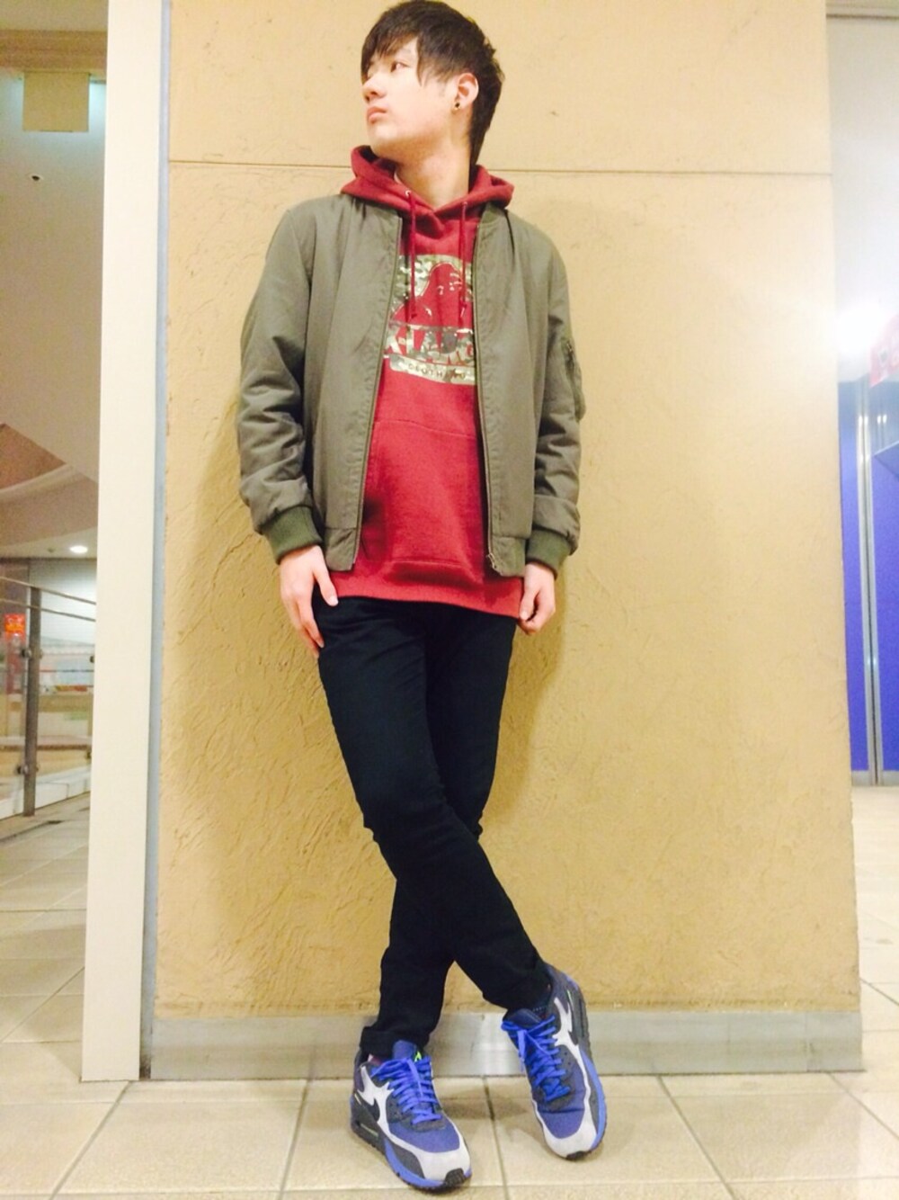 レッド系のパーカー、ブルー系のスニーカーを着用したメンズの冬コーディネートの1枚目の写真
