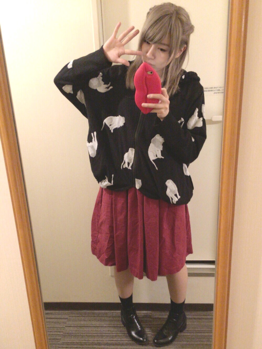 ブラック系のパーカー、レッド系のスカート、ブラック系のブーツを着用したレディースの秋コーディネートの1枚目の写真