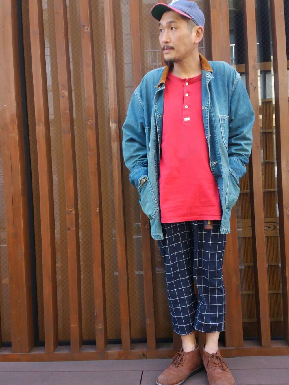 レッド系のTシャツ/カットソー、ブルー系のカバーオール、ブルー系のスラックスを着用したメンズの春コーディネートの1枚目の写真